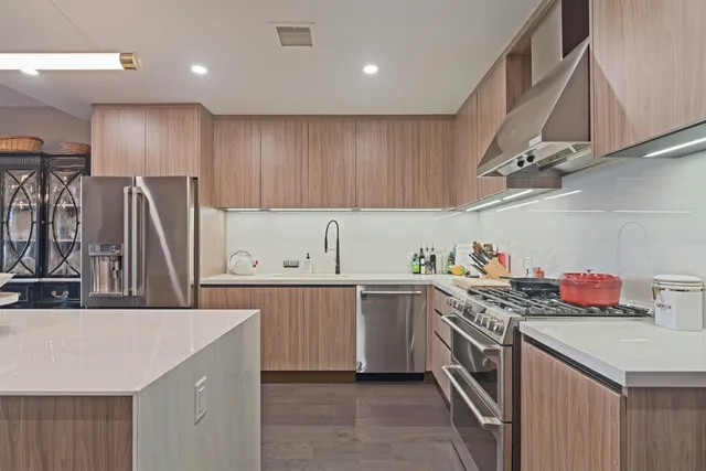 a kitchen with a sink a refrigerator and cabinets