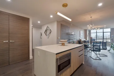 a living room with furniture a flat screen tv and a floor to ceiling window