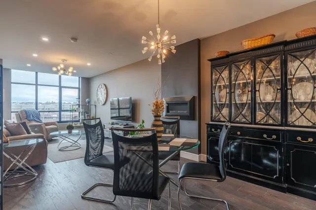 a living room with furniture a flat screen tv and a floor to ceiling window