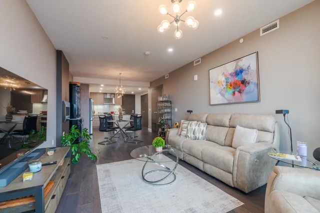 a living room with furniture and a flat screen tv with wooden floor