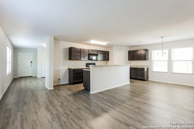 a view of a kitchen with a sink microwave and cabinets