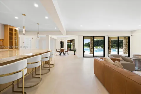 a living room with furniture a flat screen tv and a large window