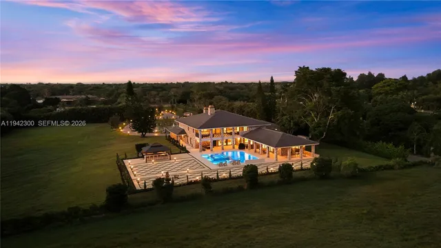 a large kitchen with kitchen island a sink a stove a refrigerator and a dining table with wooden floor