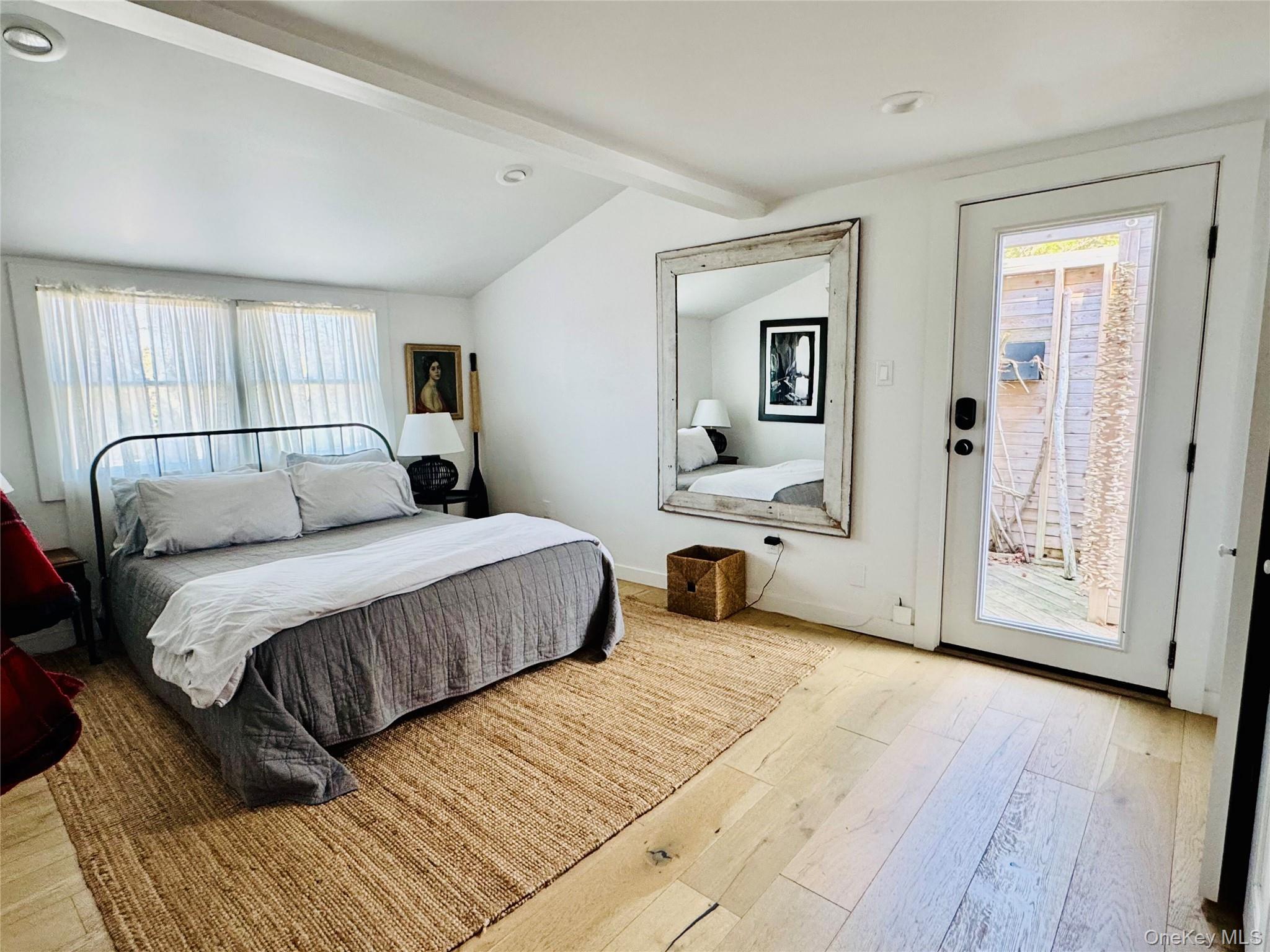106 Oak Beach Road Babylon, NY 11702 - Photo 8 of 34 a bedroom with a large bed and a chandelier