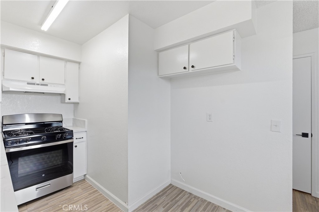 21739 Panoche Road Apple Valley, CA 92308 - Photo 11 of 49 a kitchen with white cabinets and stainless steel appliances