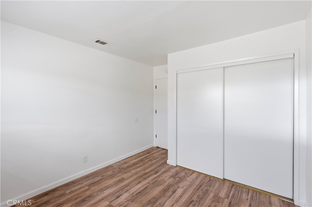 21739 Panoche Road Apple Valley, CA 92308 - Photo 15 of 49 a view of room with wooden floor