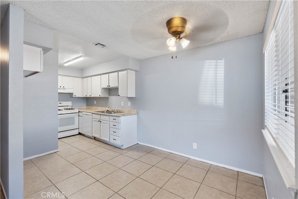 21739 Panoche Road Apple Valley, CA 92308 - Photo 26 of 49 a kitchen with a white cabinets and window