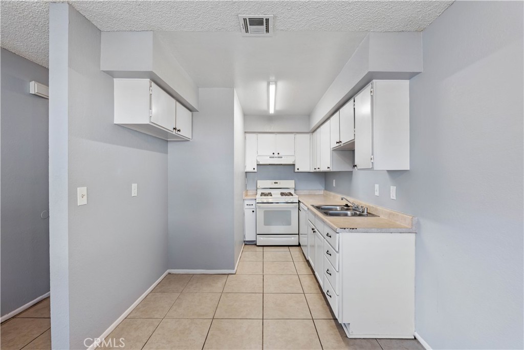 21739 Panoche Road Apple Valley, CA 92308 - Photo 27 of 49 a kitchen with stainless steel appliances granite countertop a refrigerator and a stove