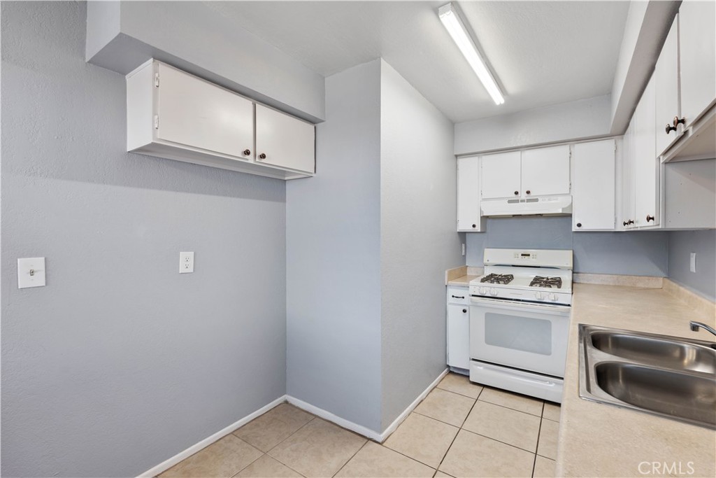 21739 Panoche Road Apple Valley, CA 92308 - Photo 28 of 49 a kitchen with white cabinets and white appliances