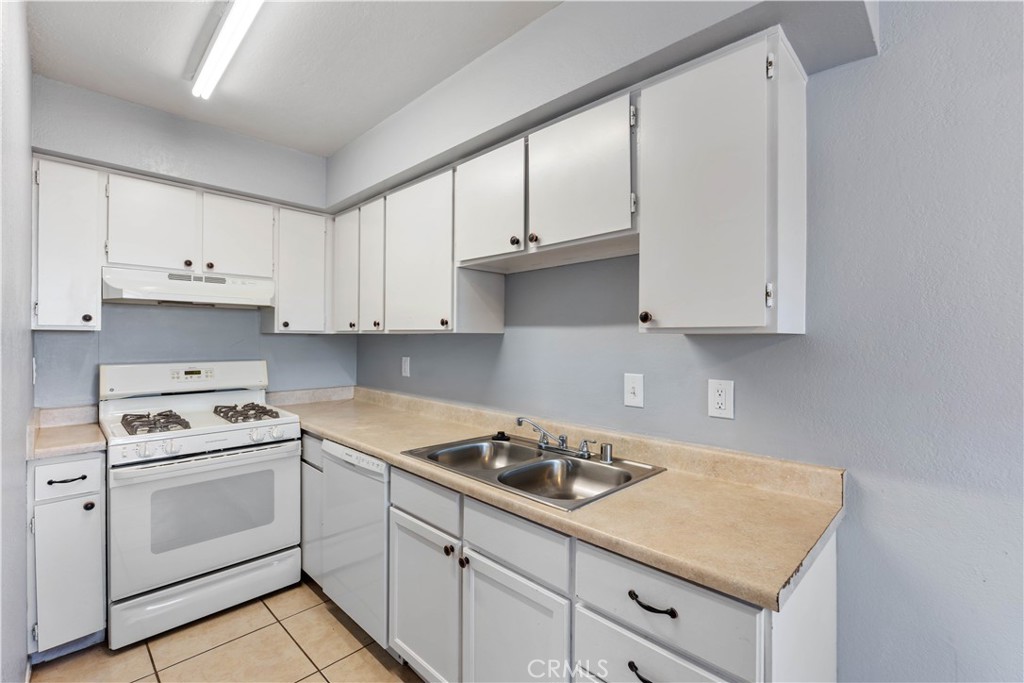 21739 Panoche Road Apple Valley, CA 92308 - Photo 29 of 49 a kitchen with white cabinets and white appliances