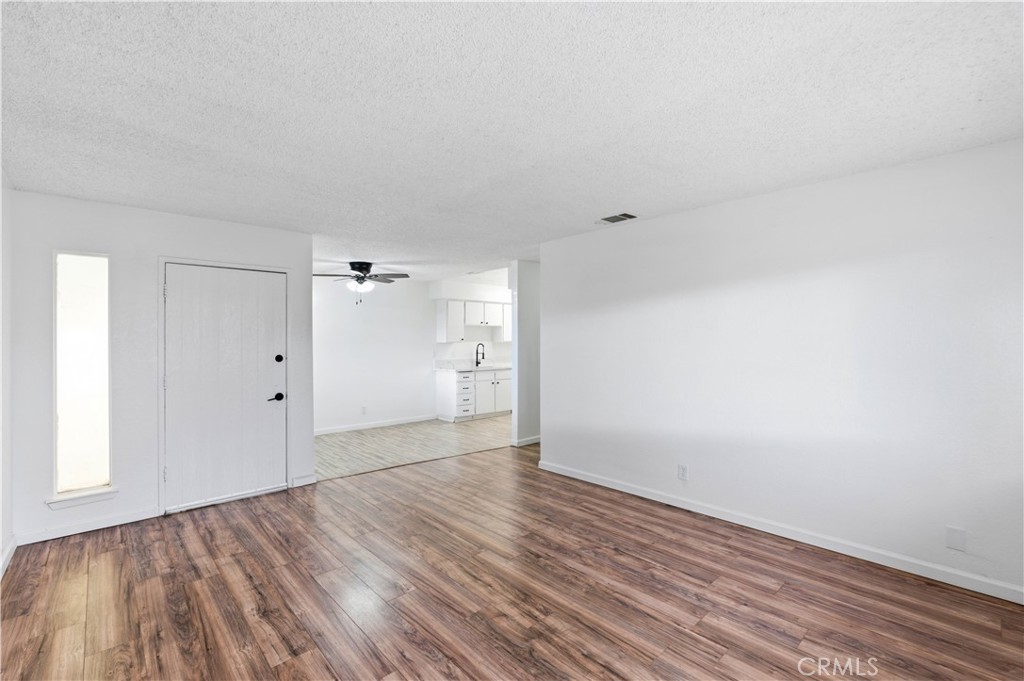 21739 Panoche Road Apple Valley, CA 92308 - Photo 3 of 49 a view of an empty room with wooden floor