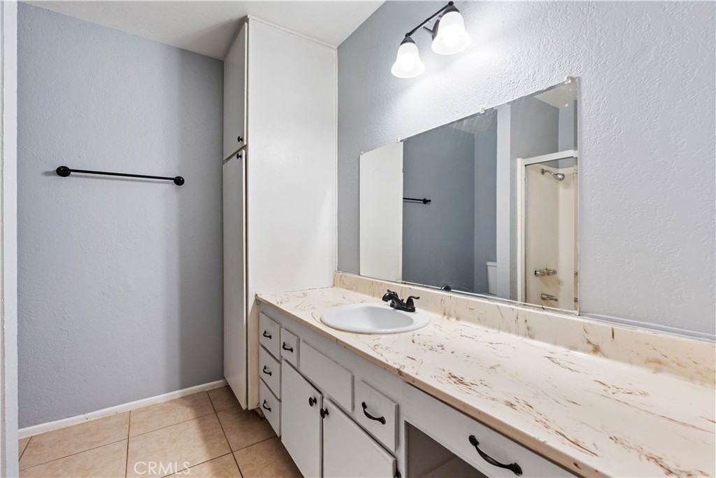 21739 Panoche Road Apple Valley, CA 92308 - Photo 34 of 49 a bathroom with a granite countertop sink and a mirror