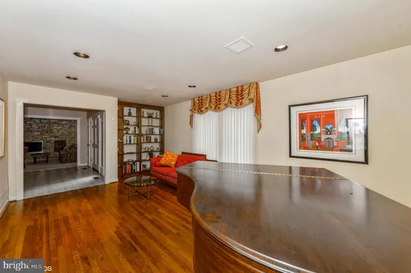 a living room with furniture floor to ceiling window and wooden floor