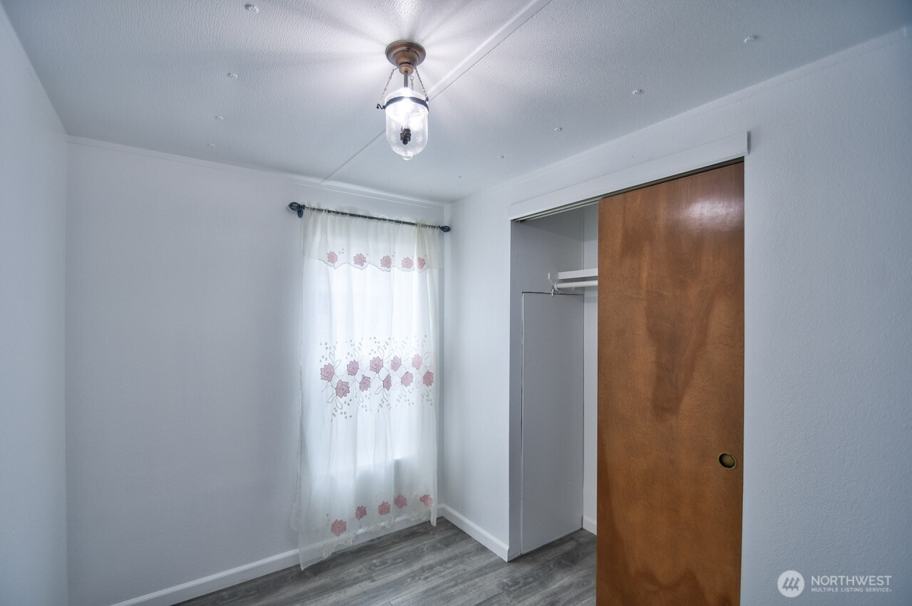 2115 Rocky Point Road Northwest, Unit 22 Bremerton, WA 98312 - Photo 15 of 16 a view of an empty room with wooden floor