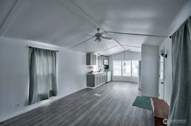 a view of a kitchen with a sink a refrigerator and wooden floor