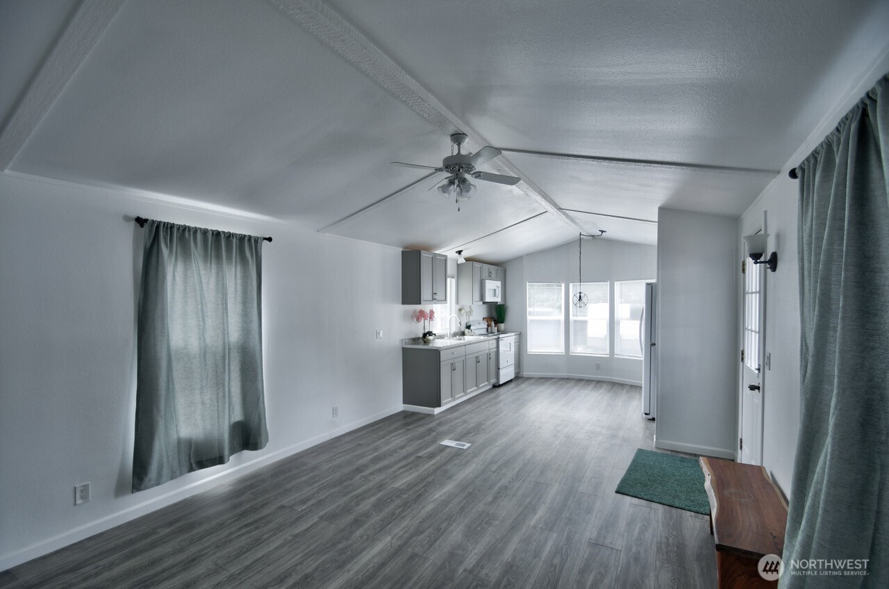 2115 Rocky Point Road Northwest, Unit 22 Bremerton, WA 98312 - Photo 16 of 16 a view of a kitchen with a sink a refrigerator and wooden floor