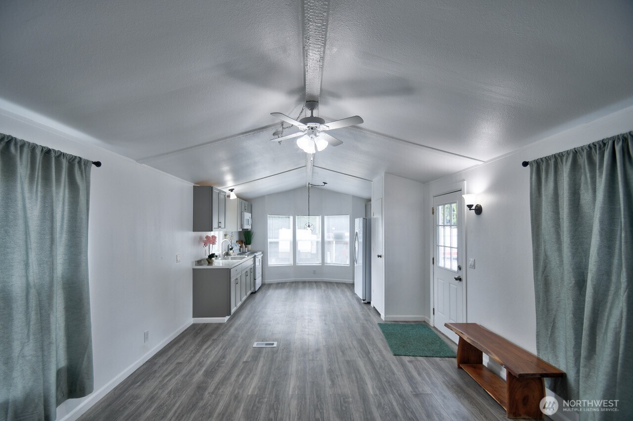 2115 Rocky Point Road Northwest, Unit 22 Bremerton, WA 98312 - Photo 10 of 16 a view of a hallway with wooden floor and a kitchen