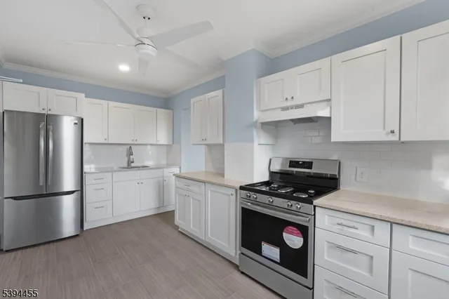 a kitchen with white cabinets and appliances