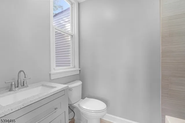 a bathroom with a granite countertop sink toilet and a mirror