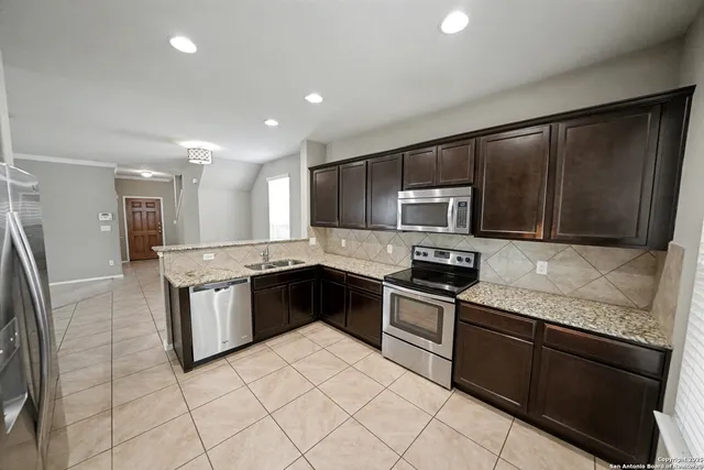 a kitchen with granite countertop stainless steel appliances and cabinets
