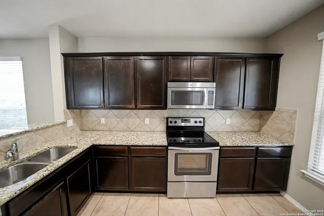 a bathroom with a granite countertop sink a mirror and a shower