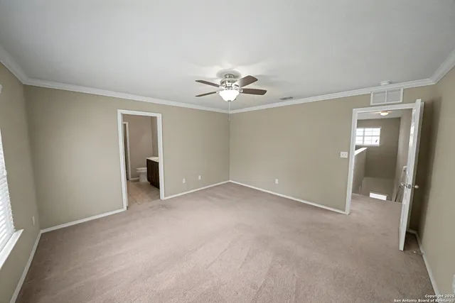 an empty room with windows and fan