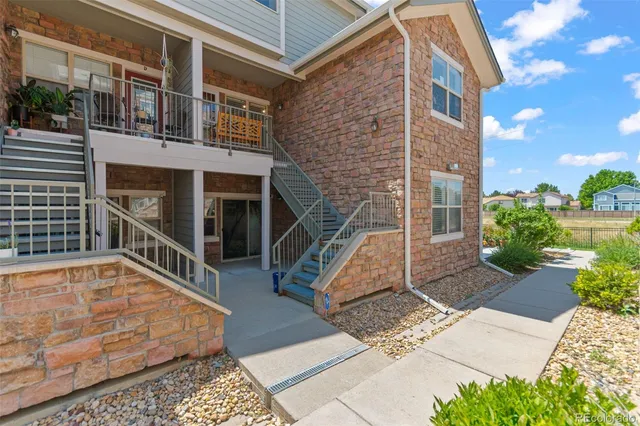 a view of a balcony with two chairs and a potted plant