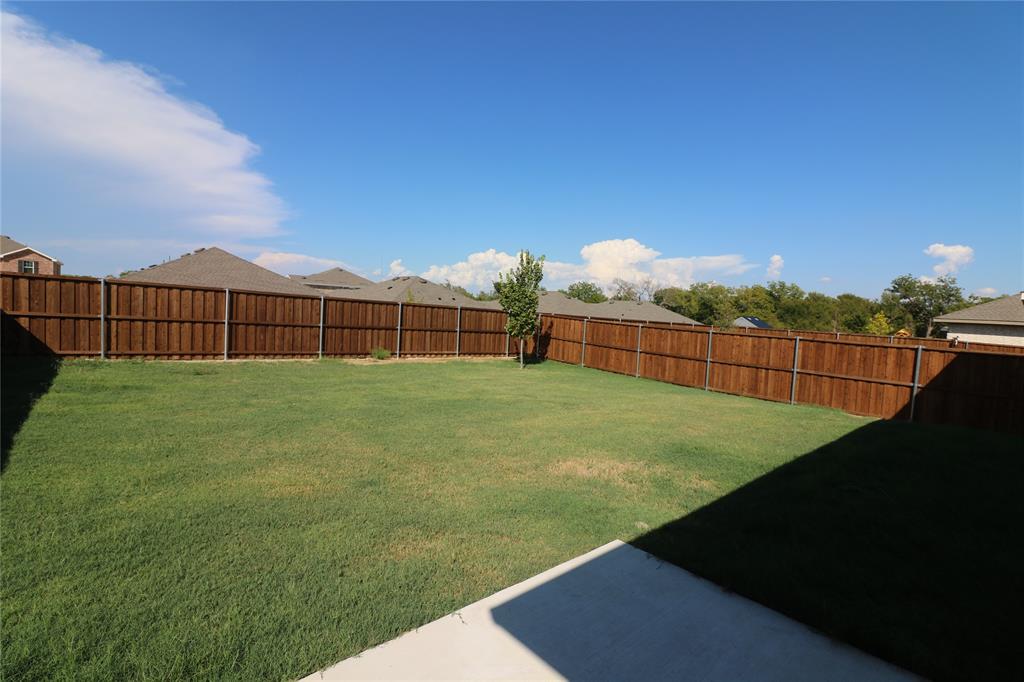 1301 Elliott Road Howe, TX 75459 - Photo 26 of 27 Expansive backyard featuring a manicured lawn, a privacy fence, and a concrete patio