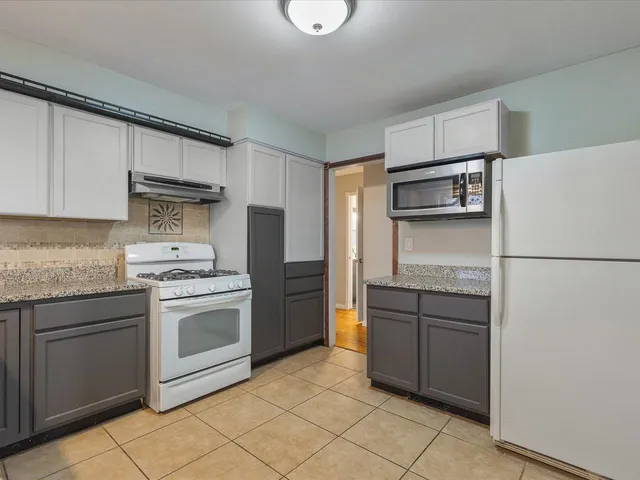 a kitchen with stainless steel appliances granite countertop a refrigerator sink and stove