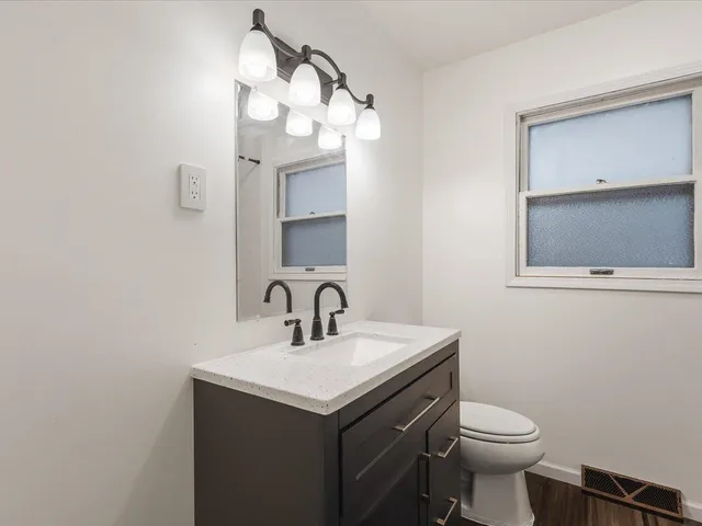 a bathroom with a sink a toilet and mirror