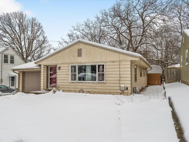 a front view of a house with a yard covered in snow