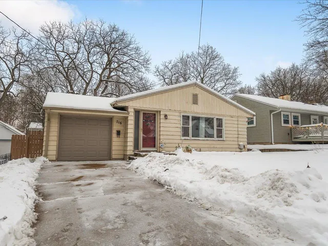 a front view of house with yard and trees in the background