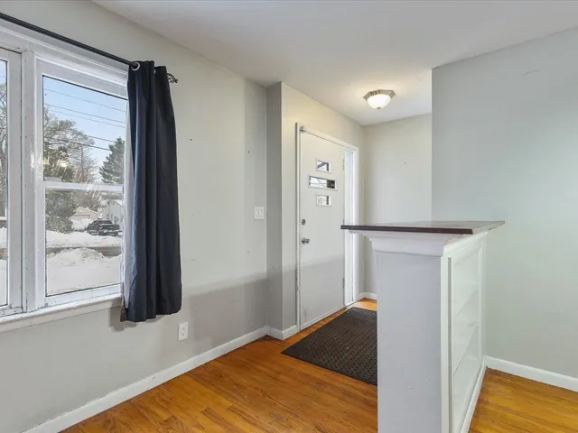 a view of hallway with wooden floor and cabinet