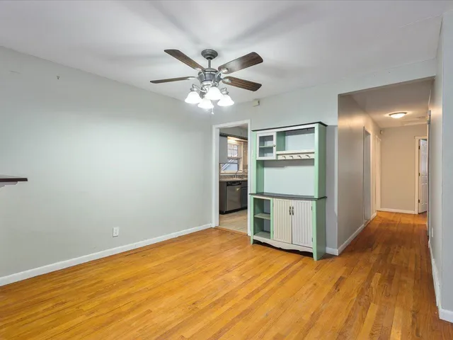 a view of a kitchen with wooden floor and a ceiling fan