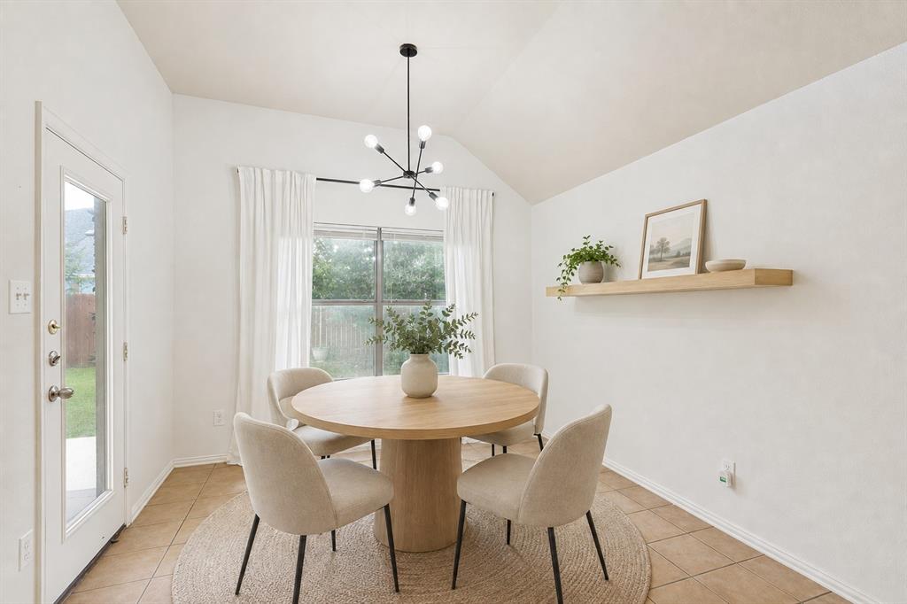 1316 Mountain Air Trail Fort Worth, TX 76131 - Photo 8 of 23 Vaulted ceiling with a modern black sputnik chandelier, full-light exterior door, large window with curtain rod, wood-finish floating shelf, and tile flooring