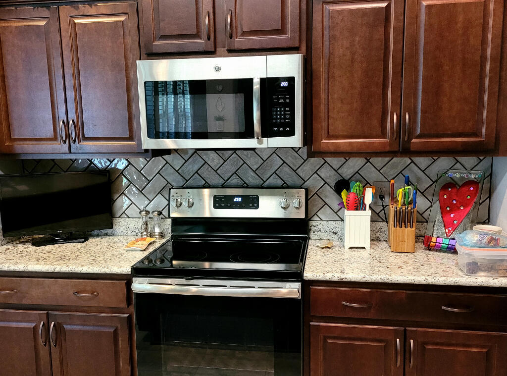 6007 Walk Along Way Crestview, FL 32536 - Photo 11 of 39 a kitchen with granite countertop wood cabinets and stainless steel appliances