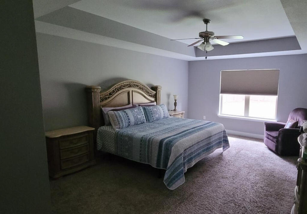 6007 Walk Along Way Crestview, FL 32536 - Photo 14 of 39 a bedroom with a bed a chandelier and dresser