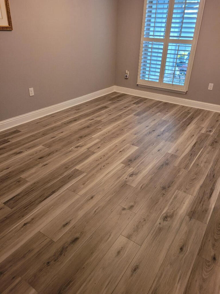 6007 Walk Along Way Crestview, FL 32536 - Photo 6 of 39 a view of an empty room with wooden floor and a window