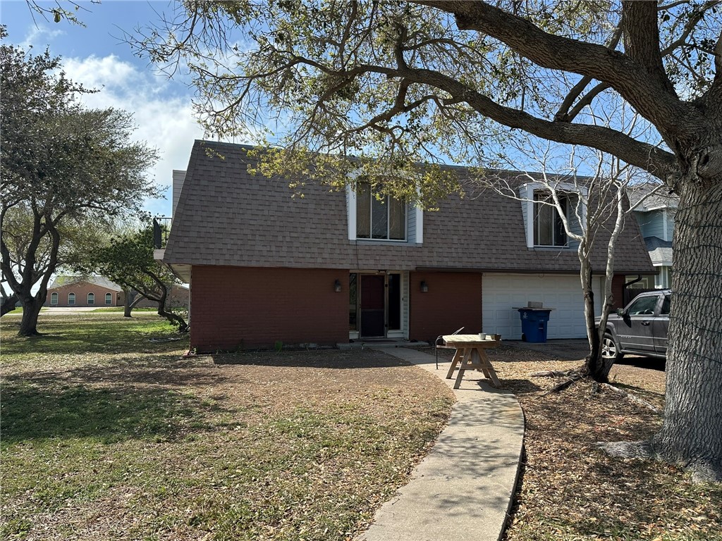 a view of a house with backyard and trees