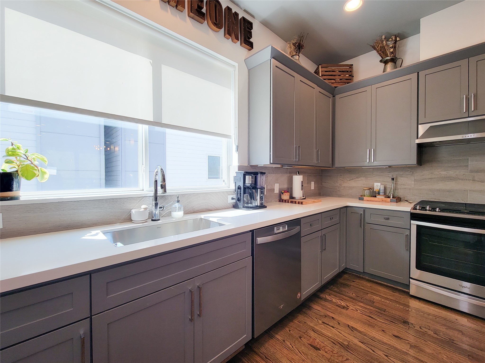 1705 Eado Point Lane Houston, TX 77003 - Photo 29 of 50 Modern kitchen with sleek gray cabinets, stainless steel appliances, and hardwood floors. Bright space with large windows and ample counter space, perfect for cooking and entertaining.