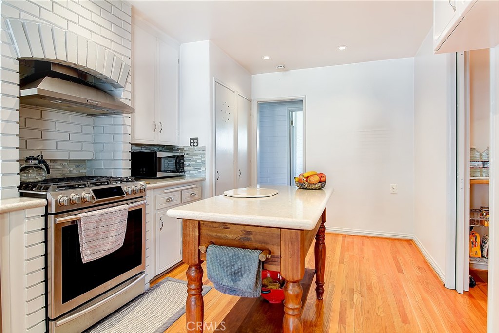 4662 Sierra Street Riverside, CA 92504 - Photo 15 of 41 a kitchen with stainless steel appliances kitchen island a stove and a refrigerator