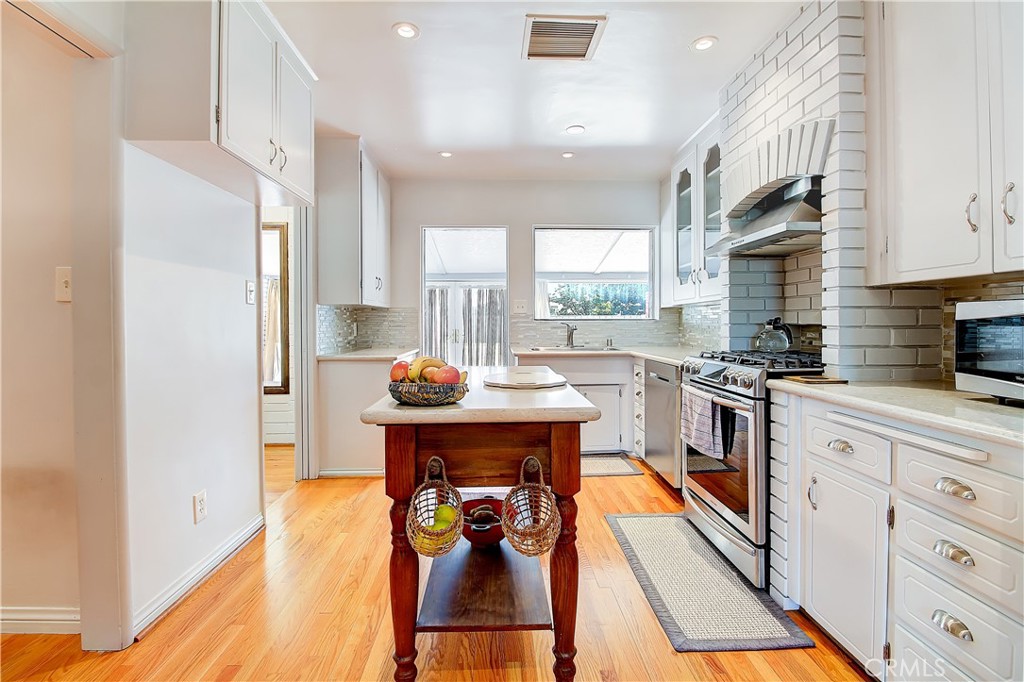 4662 Sierra Street Riverside, CA 92504 - Photo 18 of 41 a kitchen with stainless steel appliances kitchen island granite countertop a refrigerator a stove and a sink with cabinets