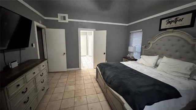 a bedroom with a bed and a flat screen tv