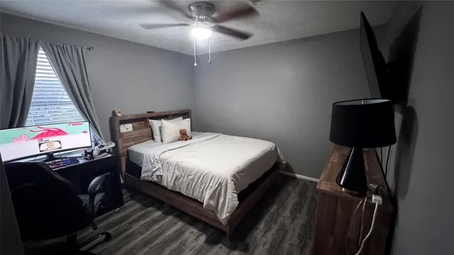 a bedroom with a bed tv and a window