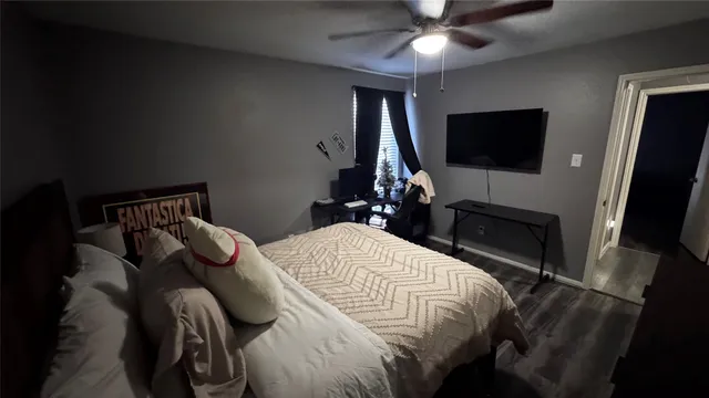 a bedroom with a bed and a flat tv screen on the dresser
