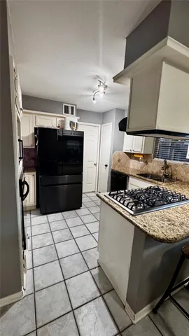 a kitchen with stainless steel appliances granite countertop a stove and a refrigerator