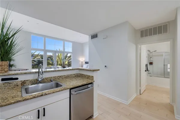 a kitchen with stainless steel appliances granite countertop a sink stove and microwave with wooden floor