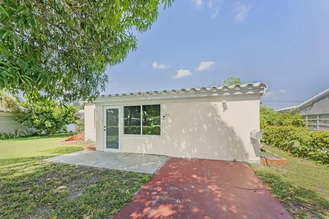 a view of a house with a yard and potted plants