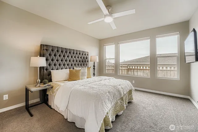 a bedroom with a bed and a large window