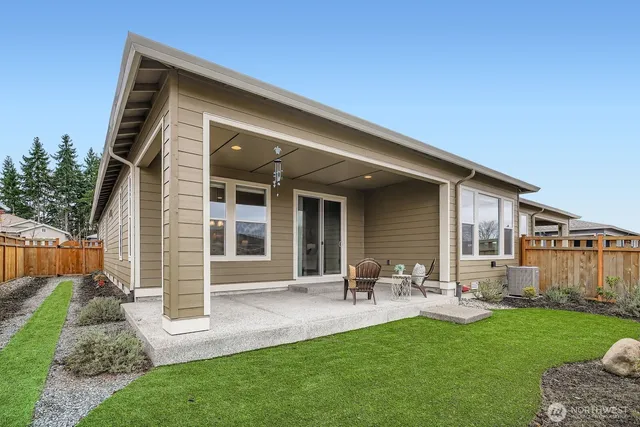 a front view of a house with a garden and chairs